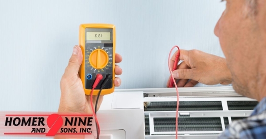 HVAC technician runs maintenance check on air conditioner.